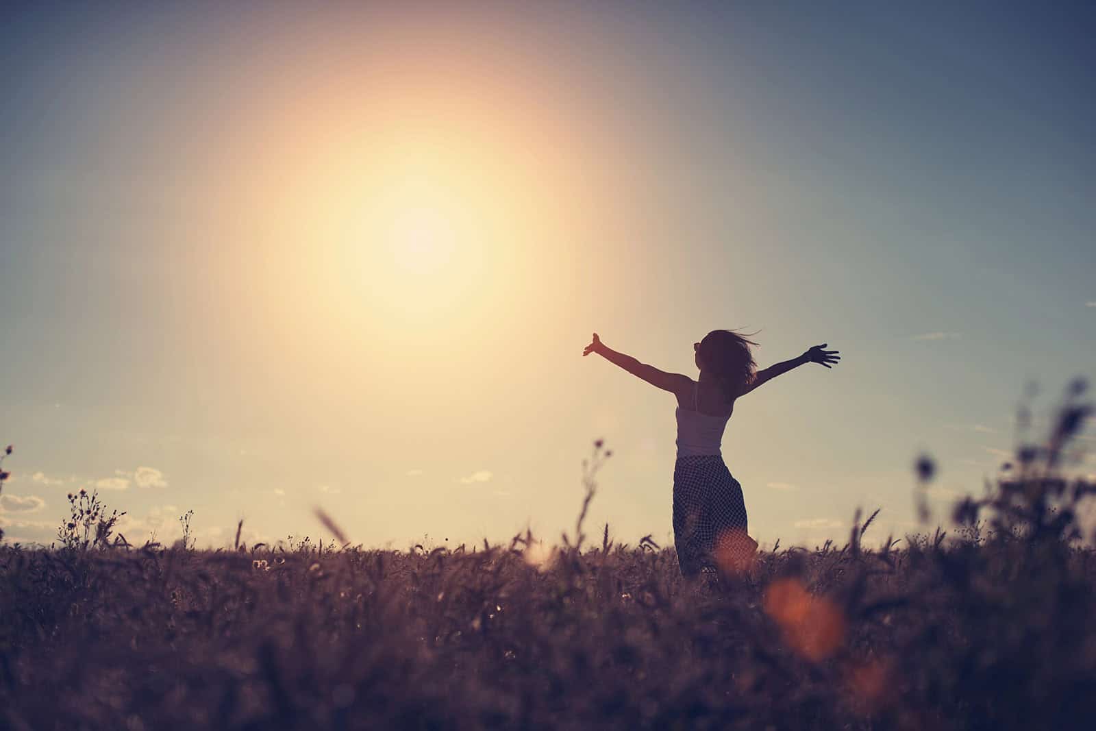 Silhouette of a girl enjoying sunset in the field (intentional s